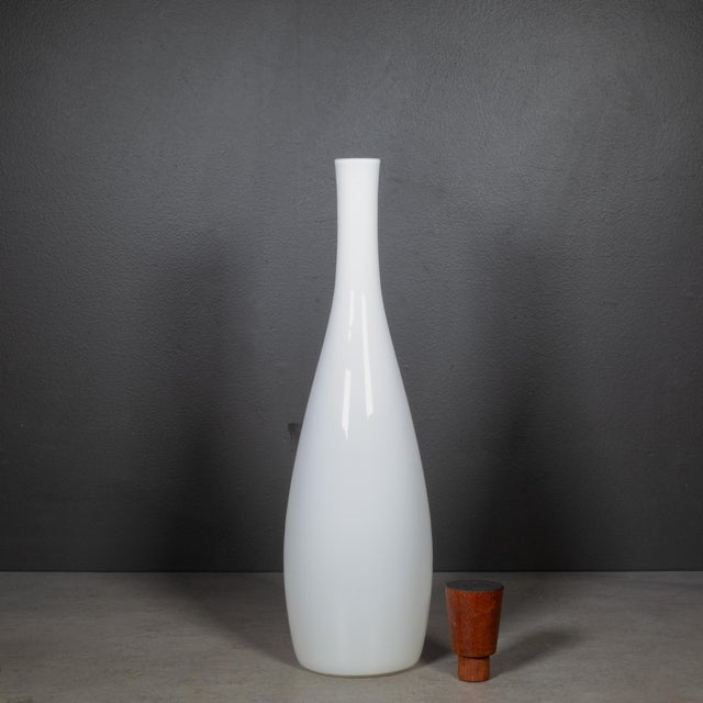 ABOUT Tall glass bottle with Teak stopper from the 1957 Opaline series. CREATOR Designed by Jacob E Bang (1899 - 1965) and...