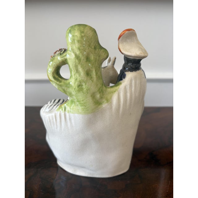 Antique Victorian Staffordshire flatback figure of a lady in period dress with a zebra carrying provisions beneath a spill...