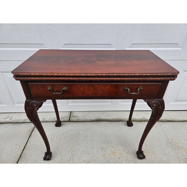 This incredible crotch or flamed mahogany console table has a flip top, converting it into a square game table. This table...