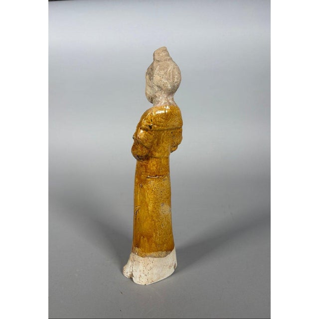 Sculpture of a Mingqi Court Lady, China, Tang Dynasty (618-907). Terracotta sculpture covered with a brown glaze. Depicts...