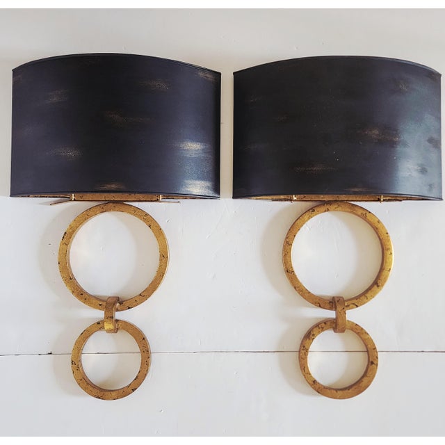 Currey & Company Bolebrook wall sconces featuring a gold leaf finish on the frames and a French black finish on the shades...