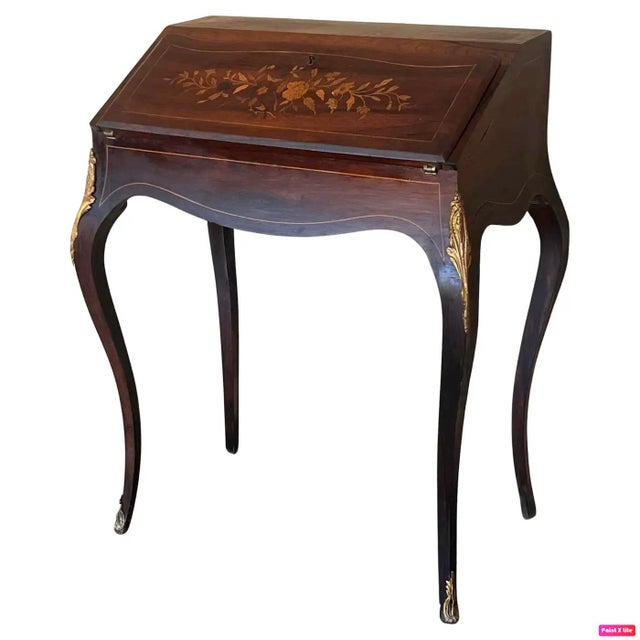 An antique early 20th century ladies' secretary desk. Made from walnut with a maple writing surface. Features a drop front...