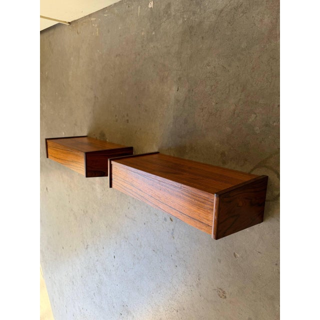 Authentic Mid-Century Modern Danish rosewood floating nightstands with drawers, circa 1960s. This rare pair features...