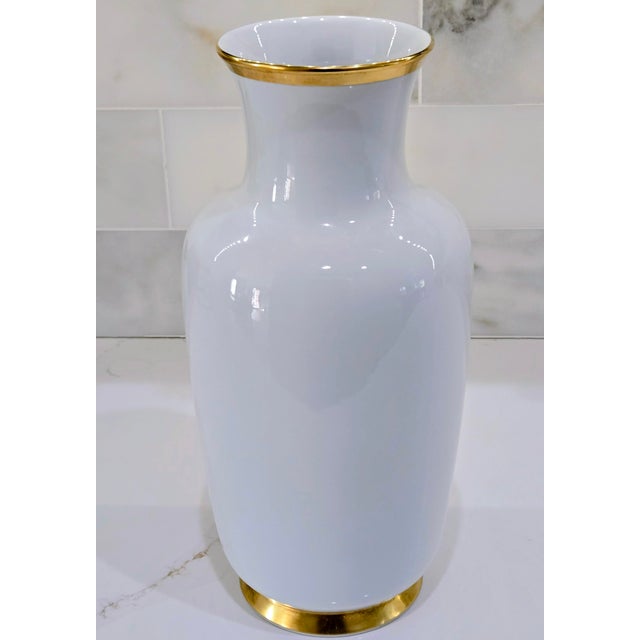 Elegant mid‑century Gerold Porzellan cabinet vase in high‑gloss white porcelain with rich gold trim at the rim and foot....