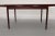 Slim, sleek and very stylish, this 1960s Danish Modern draw leaf rosewood extending dining table was manufactured by AM...