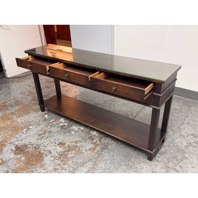 Design Plus Gallery presents a Console Table from Bassett Furniture. The brown finish wood displays visible grain across...