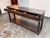 Design Plus Gallery presents a Console Table from Bassett Furniture. The brown finish wood displays visible grain across...