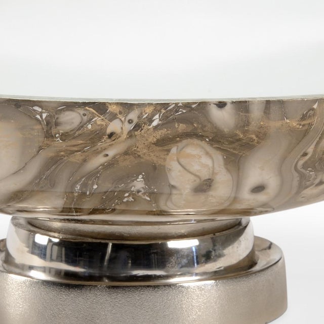 Be mesmerized by the swirls of the calacatta gold... Sitting atop an aluminum base with a polished nickel finish, cream,...
