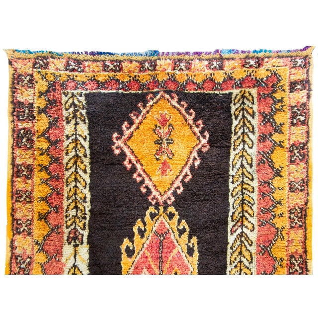 A wonderful mid-20th century Moroccan rug with three large central diamond medallions with stylized floral borders, set...