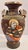 A dark brown-ground Satsuma-style vase with hand-painted figures set in gilt-framed medallions around the body. Each...