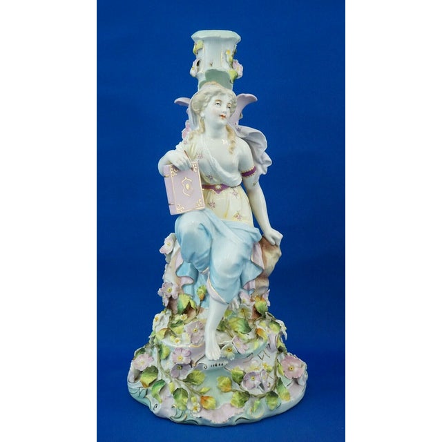 Item : A magnificent hard-paste porcelain candlestick featuring a central woman, depicting the muse of poetry, embellished...