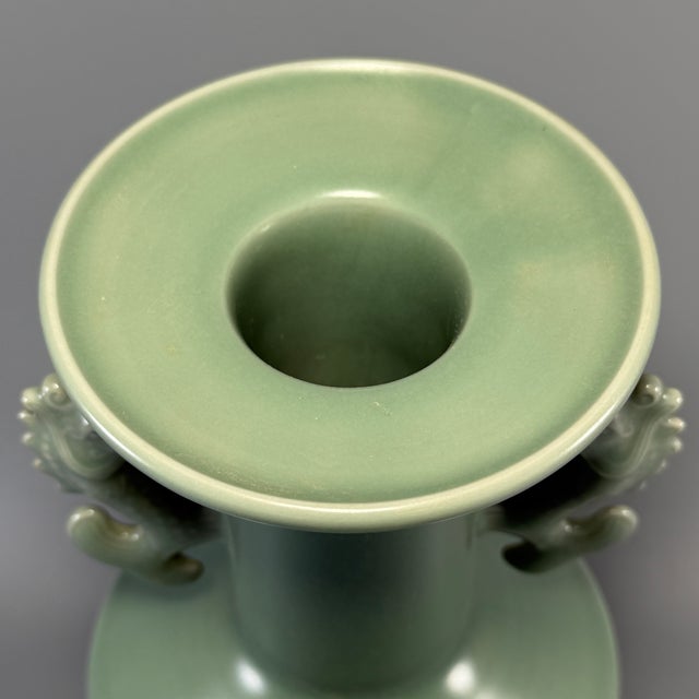 This exceptional vessel is a classic Chinese Longquan celadon vase, adorned with a pair of vivid dragon-carp (fish-dragon)...
