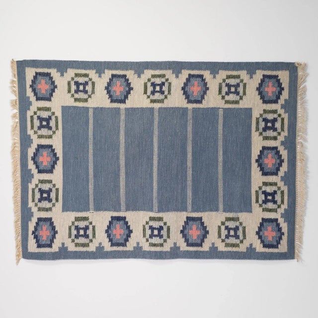 Mid-Century Swedish kilim in the manner of Ingergerd Silow. In tones of blue and cream, with a scalloped border. Circa 1960.