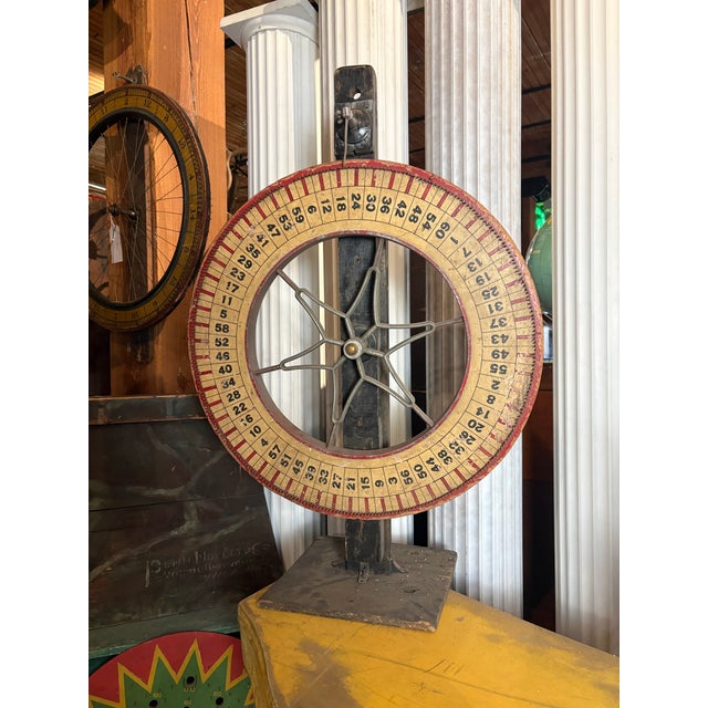Vintage tabletop carnival game wheel featuring a hand-numbered wooden wheel and original metal star-spoke mechanism....