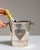 This mid 20th century ice bucket from France is finished in gold, worked in silver. It is fitted with a heart-shaped...