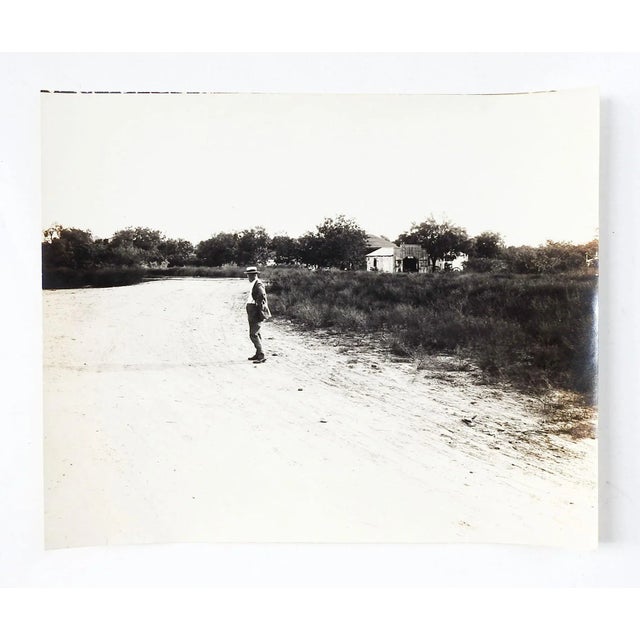 1919 silver gelatin photograph of a man standing on a loney dirt road. Note on back stated taken July 30th 1919 by C. O....