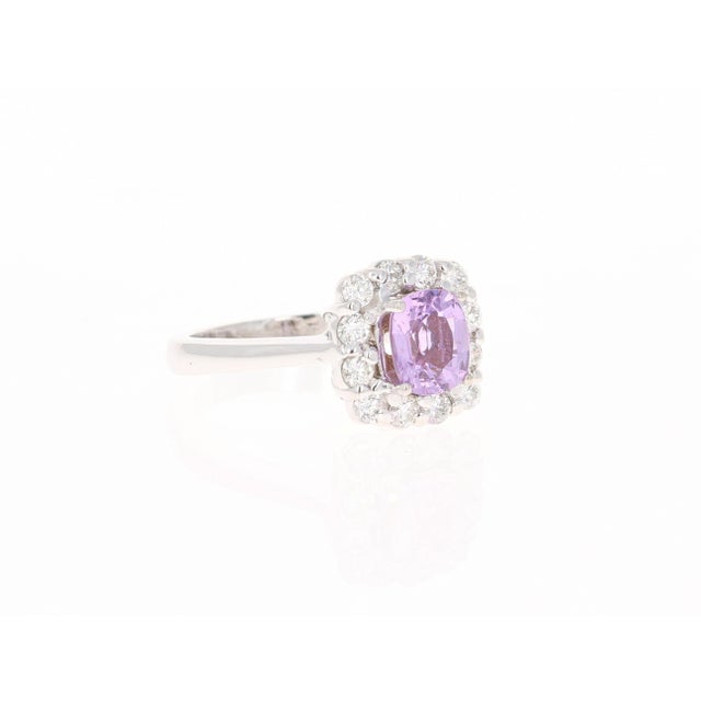 This ring has a Cushion Cut Pink Sapphire that weighs 1.49 carats. It also has 12 Round Cut Diamonds that surround the...