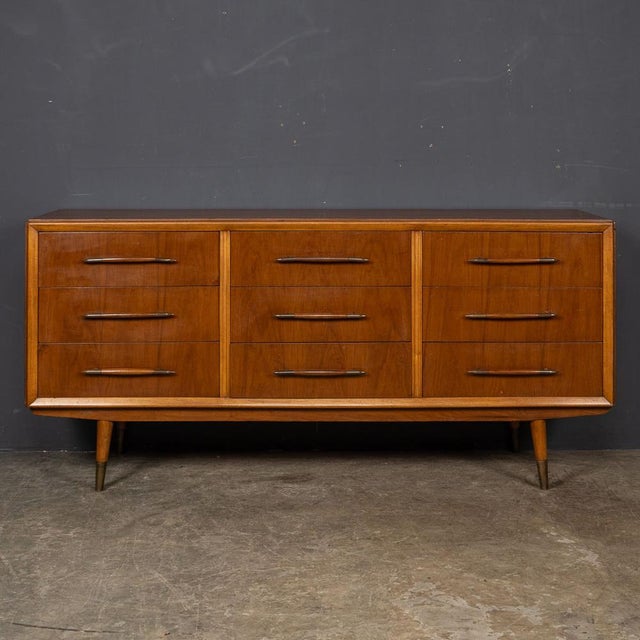 An Italian-made wooden credenza from the captivating mid-20th Century era. This distinguished piece features a total of...