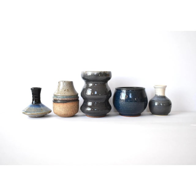 A collection of 5 pottery vessels by various artists, including a 5.6" triple-tier blue vase, a 4.5" speckled and striated...