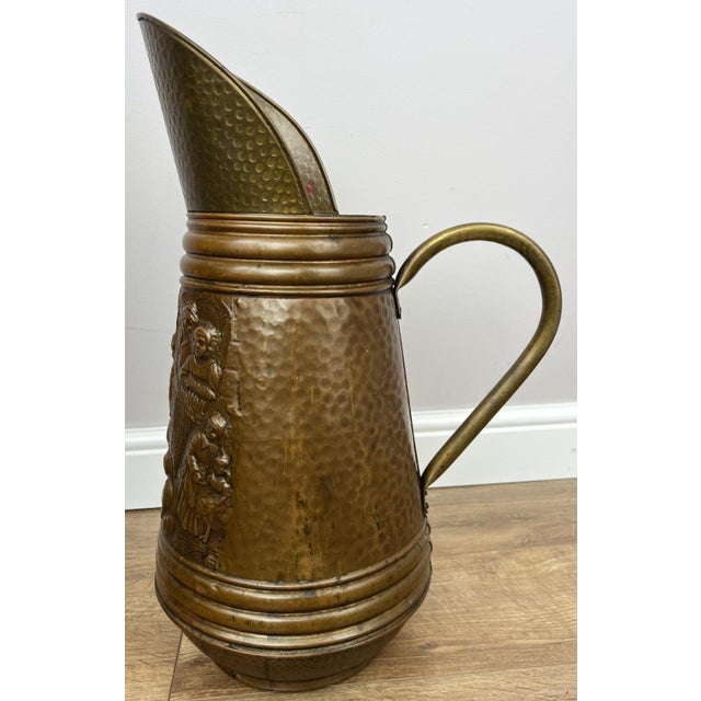 A striking vintage copper umbrella holder featuring beautifully embossed decorative scenes and a richly textured hammered...