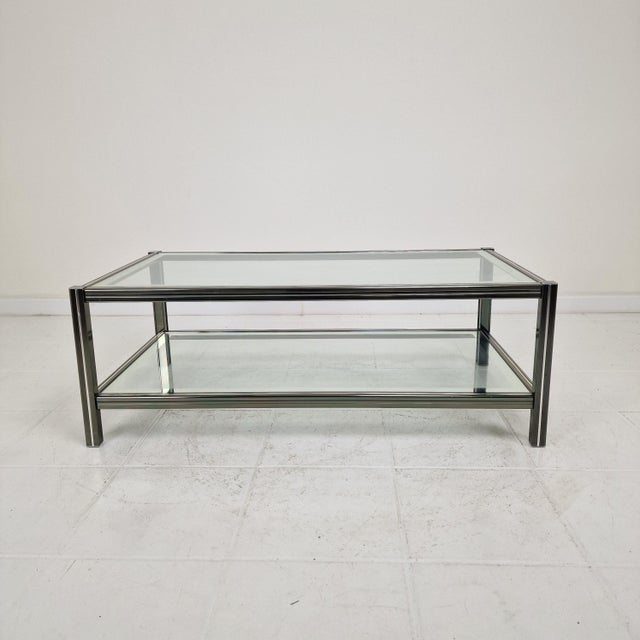 Stylish vintage coffee table with a sleek and timeless design. The table features a sturdy metal frame and two glass...