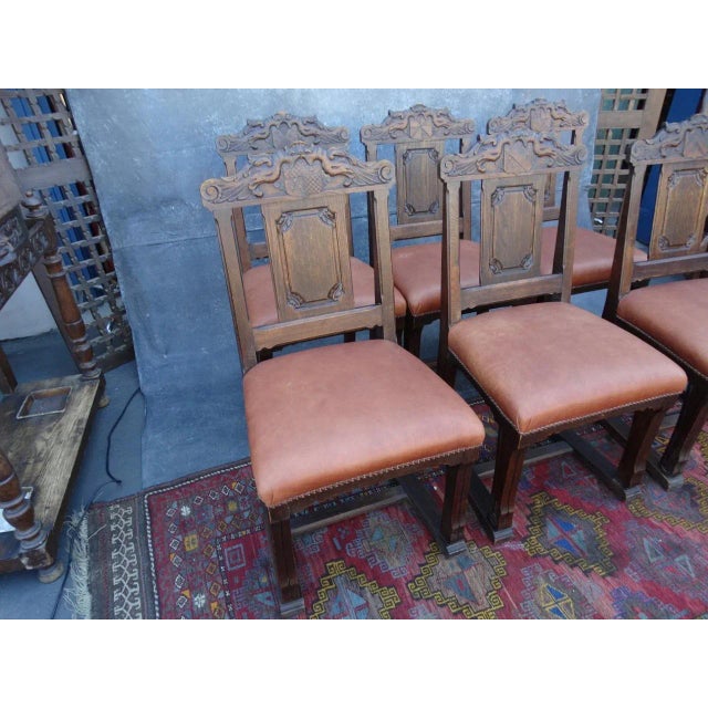Each measures 41 1/2" high x 22" deep x 20 wide, seat height 21". Chairs have leather seats and hand-carved backs. Leather...