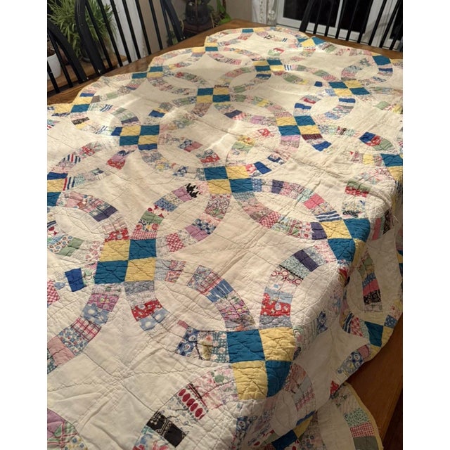 This Vintage Handmade Double Wedding Ring Quilt features a scalloped edge and measures 70” x 70”. Made from cotton with a...