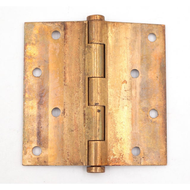 This vintage door hinge is made of polished brass with flat tips, five knuckles, and a staggered hole pattern. The...