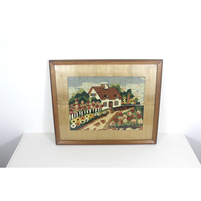 Charming 1930’s vintage crewel embroidery art of a cottage and flowers in a wood frame with wood matting and glass front....