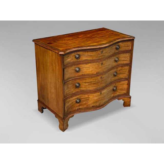 A very fine George III period late 18th-century mahogany chest of drawers. It features a serpentine moulded cross-banded...