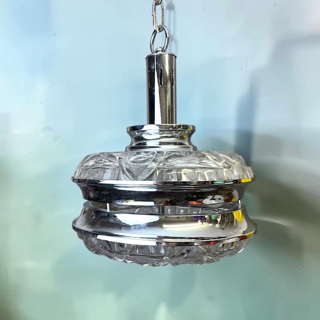 Fine example of the Mid Century or early 1970s design, this pendant light is made of thick cut glass and chromed metal....