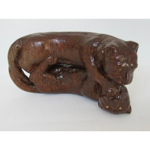 An antique Asian decorative sculpture depicting two intertwined panthers, hand-carved from a single block of dense...