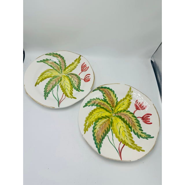 This is a pair of hand-painted Italian ceramic plates by La Ceramica, each capturing a lively, painterly expression of...