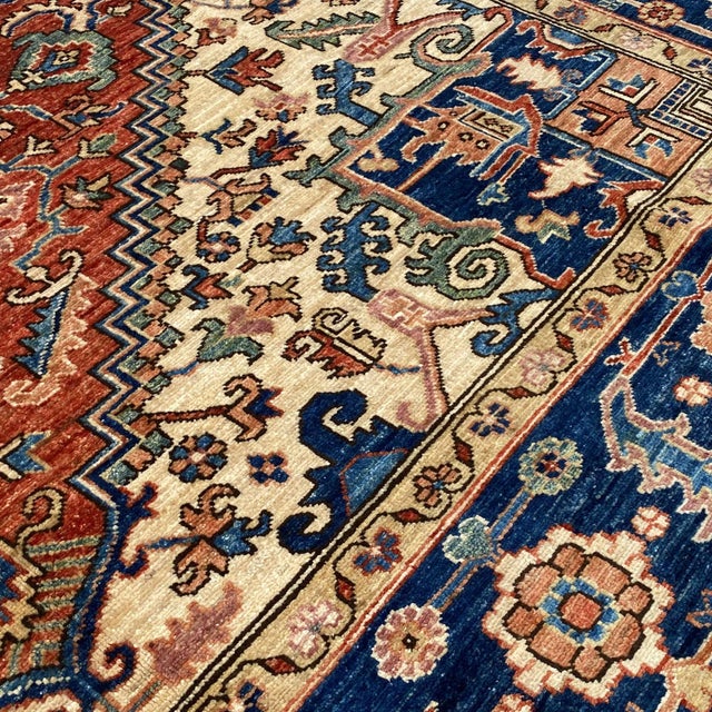 Fine Persian Heriz hand-knotted rug featuring a bold central stepped medallion in deep rust and navy, framed by ivory...