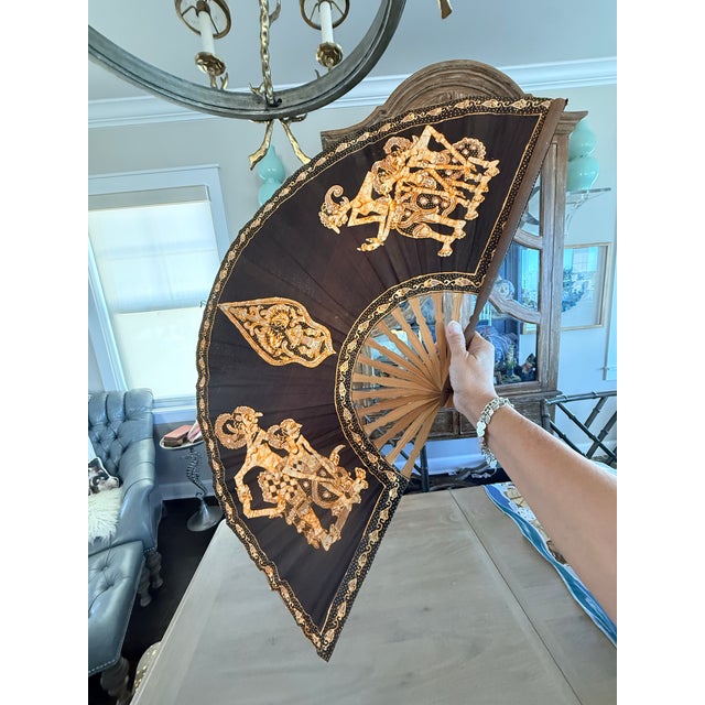 Large Batik folding fan. The fan is 18” long when folded and spans approximately 33” when fully expanded. Made of bamboo...