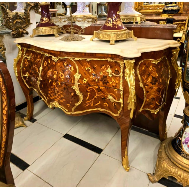 A true masterpiece of French-inspired luxury, this stunning Louis XV Bombe Commode showcases an elegant serpentine...