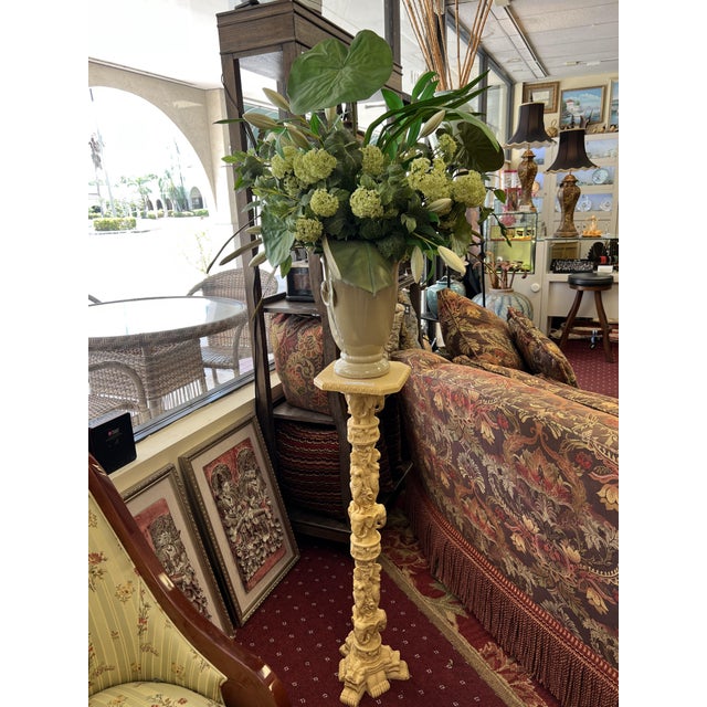This Italian-made pedestal blends artistry and exoticism. Crafted from an ivory-colored composite, it features intricate...