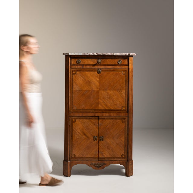 This 19th century Louis XVI secretary cabinet with marble top from France is made in figured, quartered veneer with a...