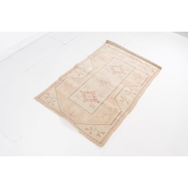 This is a vintage Turkish Oushak rug from the Mid 20th Century. The piece was hand-knotted.