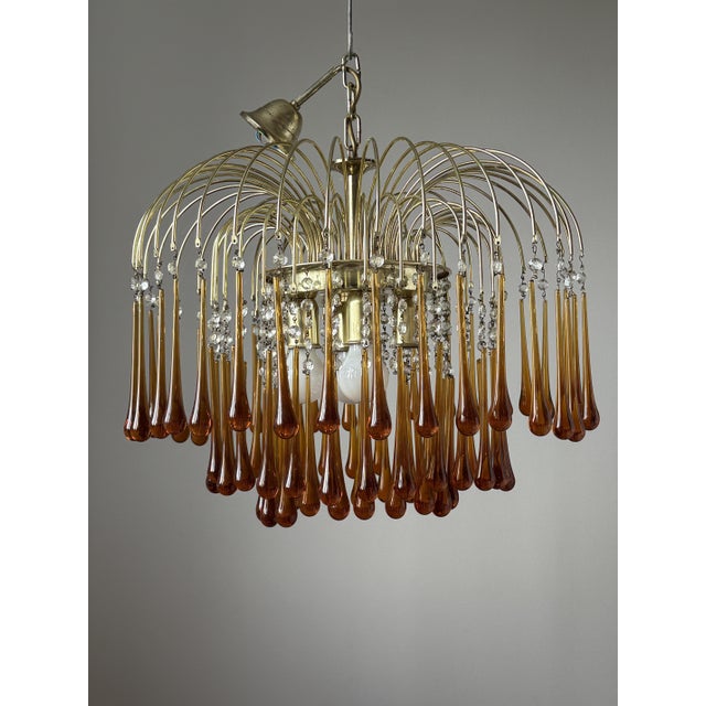 A striking designer chandelier made of Murano glass, created after a 1960s design by Paolo Venini. The brass structure...