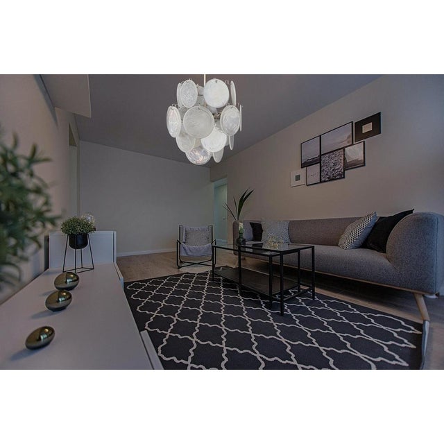 Vintage Italian Murano chandelier in Vistosi style. The chandelier has 24 fantastic iridescent alabaster white discs in a...