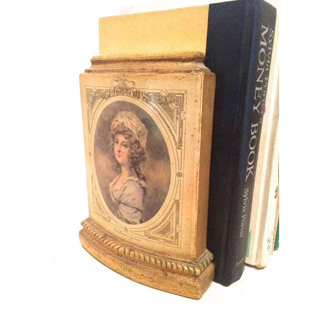 Beautiful pair of book ends depicting male and female period portraits. Gold and beige from Classic Borghese. Metal stand...