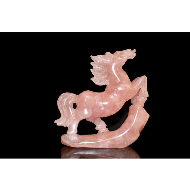 A finely hand-carved sculpture of a rearing horse, executed in natural rose quartz of soft, luminous blush tone. The...