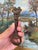 A vintage cast iron bottle opener featuring a sculptural figural design of two nude female forms conjoined at the torso....
