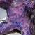 Ceramic table lamp with violet-pink glaze, shaped as a twisted pyramid. The four legs are modeled as heads. The lamp...