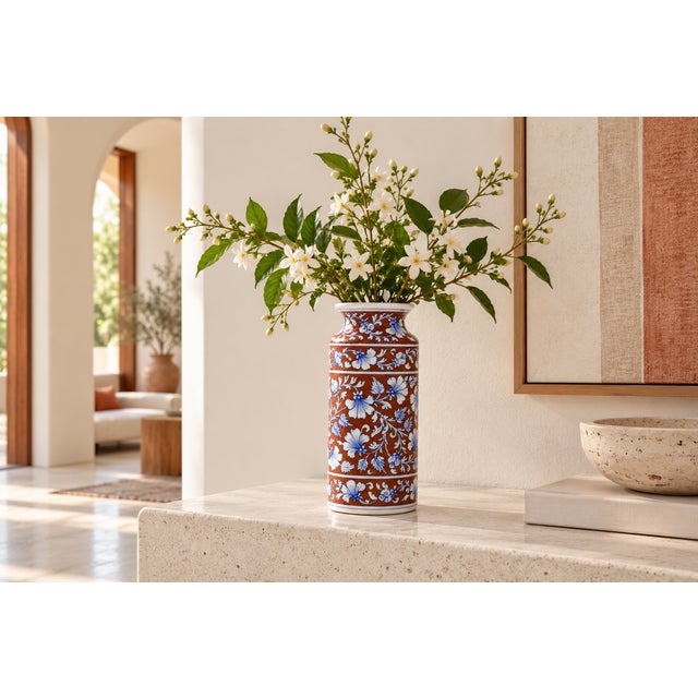 A tall, graceful baluster vase hand-painted in the rich, saturated palette Jaipur is known for: a deep rust-brown ground...