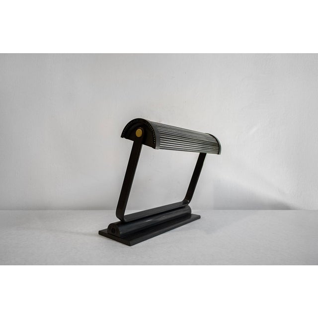 Desk lamp with metal frame and glass shade. Eubea model Designer Alberto Fraser Manufacturer Artemide 1980s This piece has...