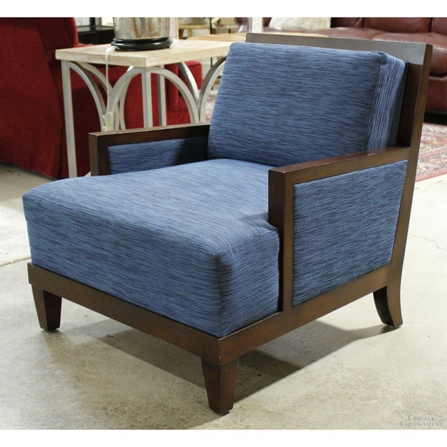 This lounge chair features a clean-lined wooden frame with a dark finish and gently angled legs. The seat and back...