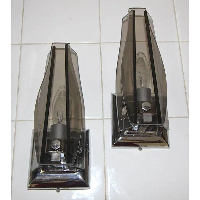 Italian smoke glass and chrome wall sconces in the manner of Fontana Arte. Each sconce uses 1 candelabra base bulb, newly...