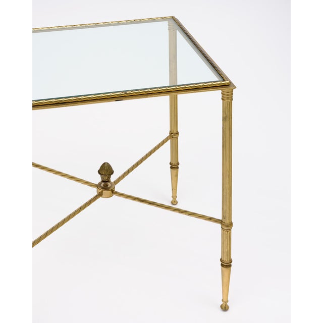 Side table from the Art Deco period in France. This table is made of solid brass with four tapered legs. The four legs are...